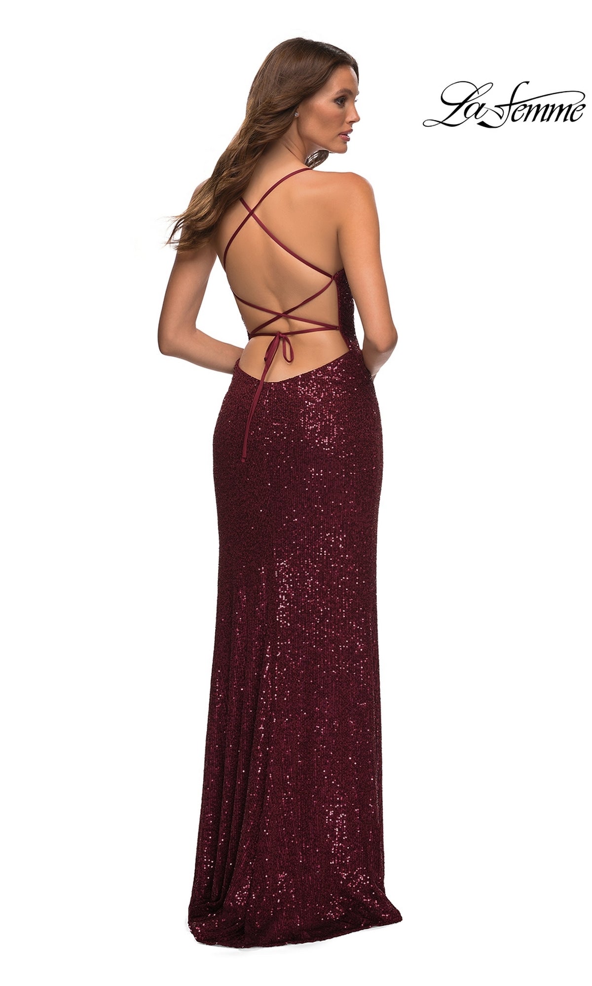 Woman in a La Femme Strappy Faux-Wrap Long Sequin Prom Dress in burgundy, featuring a crisscross open back, stands facing away from the camera.